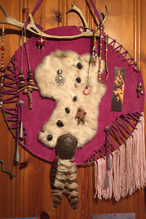 ritual object with beads, feathers and fringe